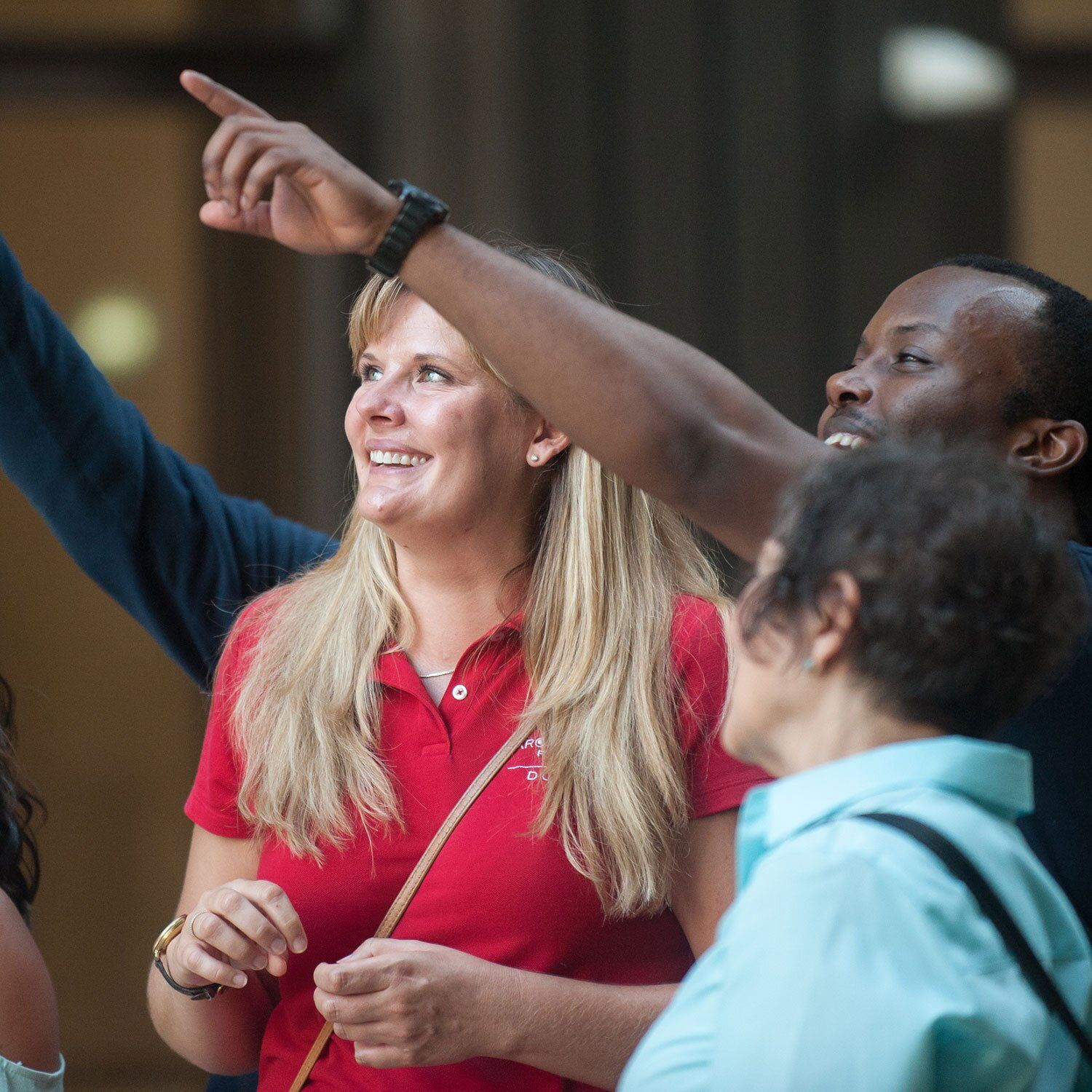 A group of people outside. The center figure is a blond woman in a red CAC polo shirt. Photo courtesy of CAC/ Anna Munzesheimer
