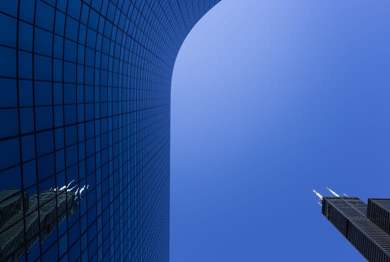 Exterior image of a buiding covered in glass windows looking up from below