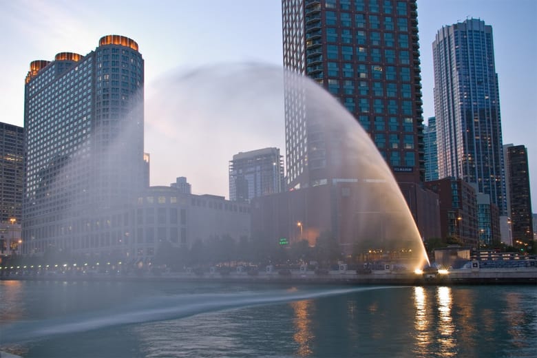 An arc of water shoots across the Chicago River