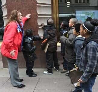 Photo of a group of children touching a building