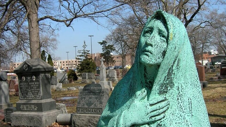 green sculpture of a woman in a shroud