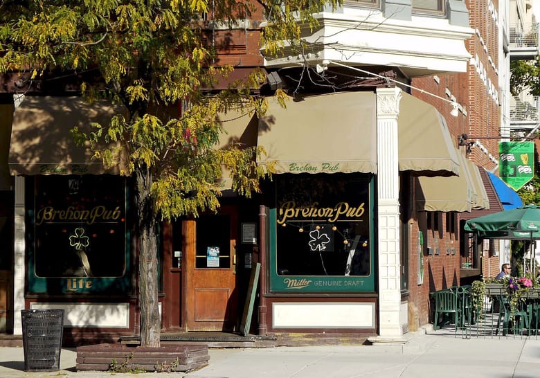 Exterior of Irish pub on street corner; red brick building with beige awnings