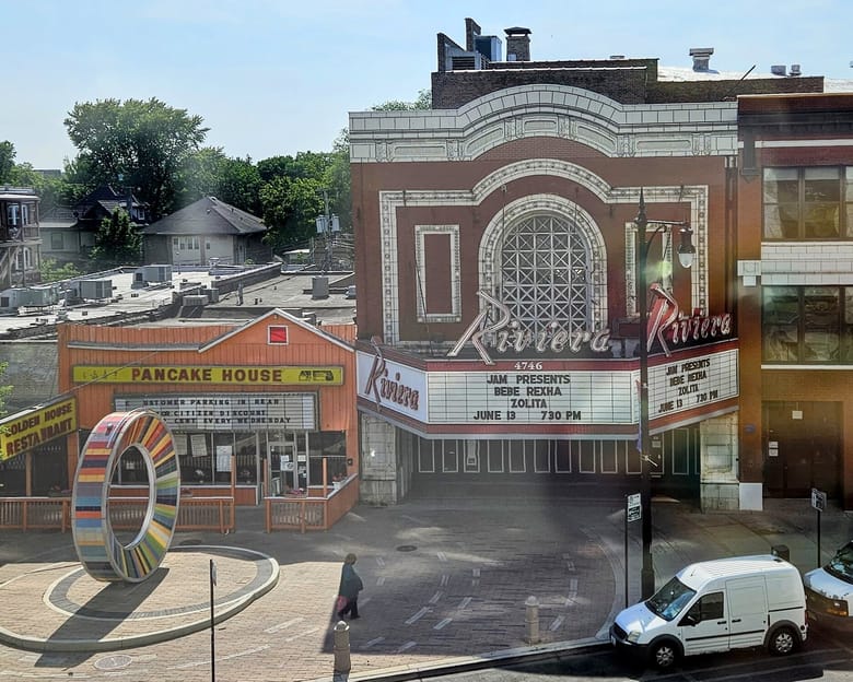 Aerial view of theatre with large white marquee next to restaurant with yellow sign