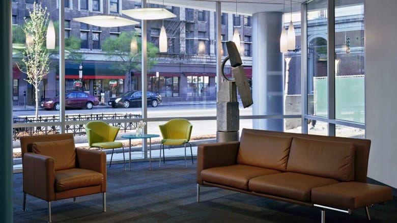 Inside the lobby of the building with two camel colored couches
