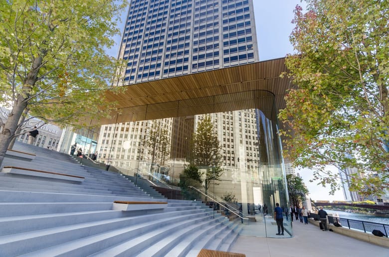 Exterior shot of the side of the Apple store, a building with all glass walls and stairs going up the side of the building