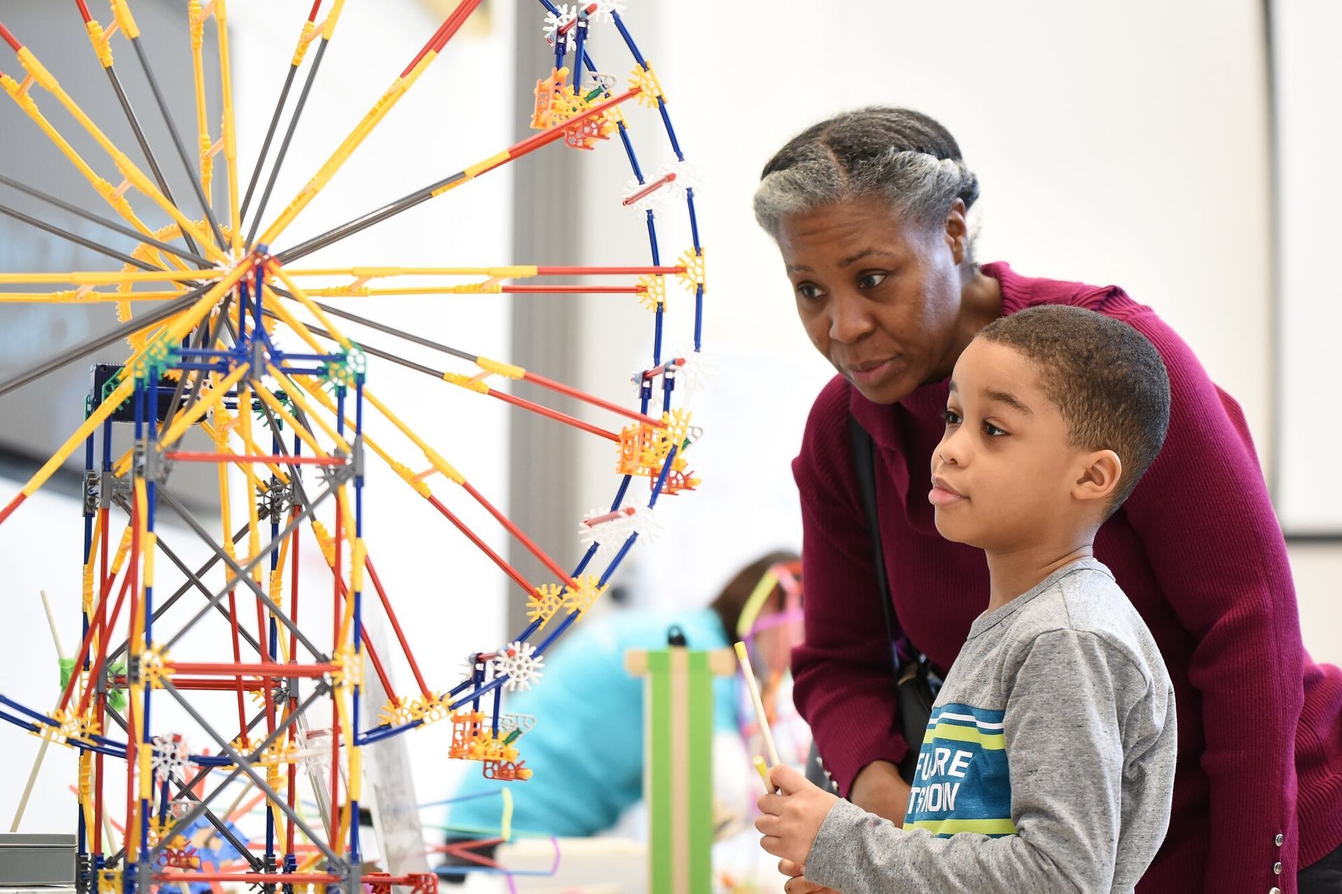 Image of an African American woman and child looking at a scale model of a ferris wheel.