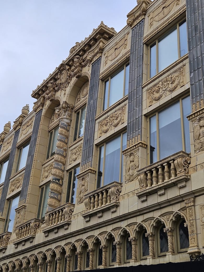 3 story terra cotta building with arched windows