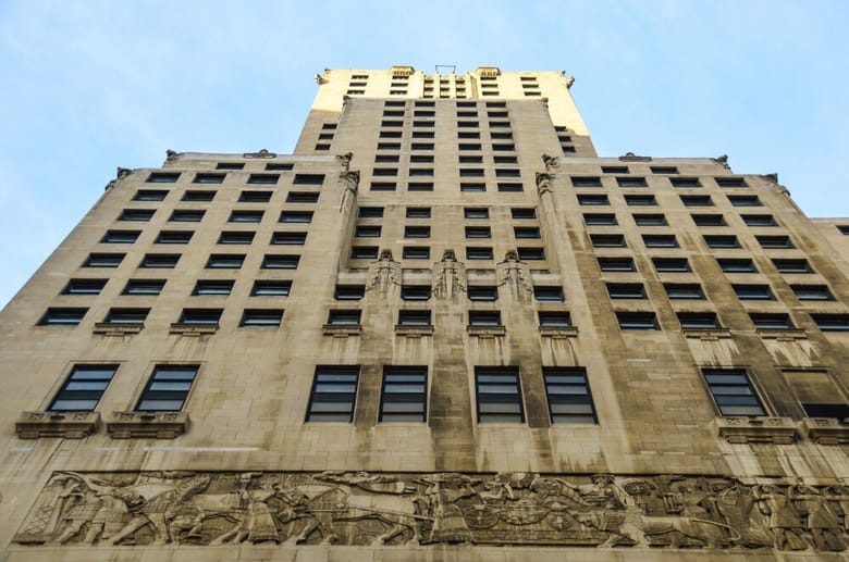 Looking up at large beige building with many windows