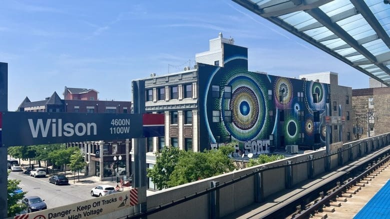 View from elevated train platform onto city street with mural