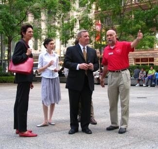 Image of 4 Figures standing on a city plaza