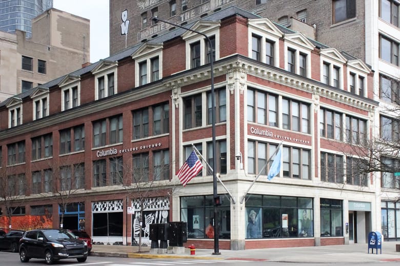 Image of a four story red brick building with white accents.