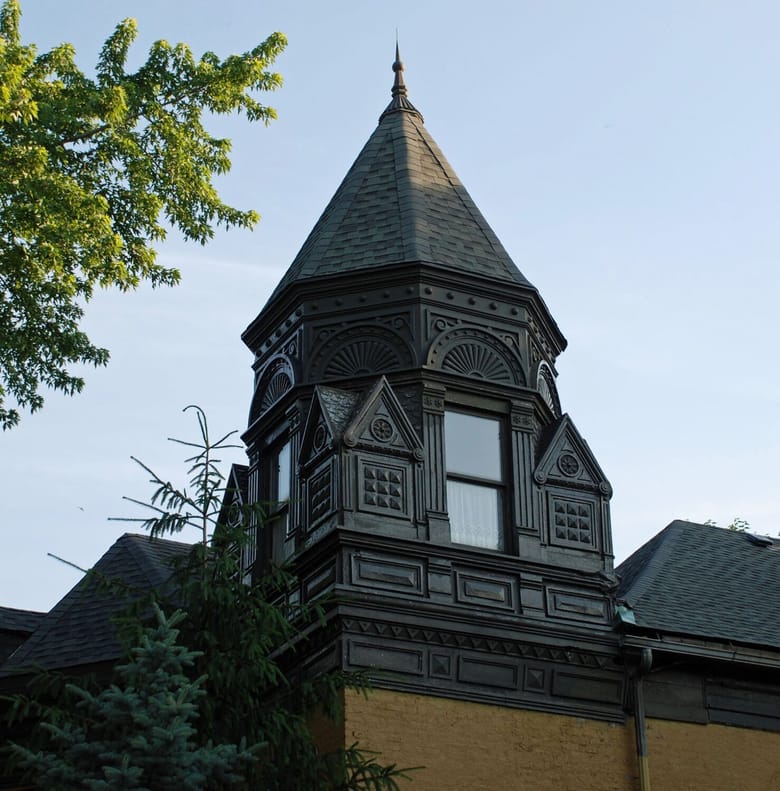 Top of a black building with ornate carvings