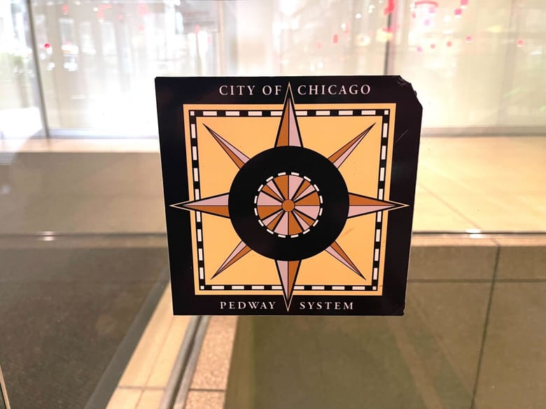 Chicago Pedway logo featuring a stylized design representing the city's underground pedestrian walkway system, commonly used for navigation in downtown Chicago.