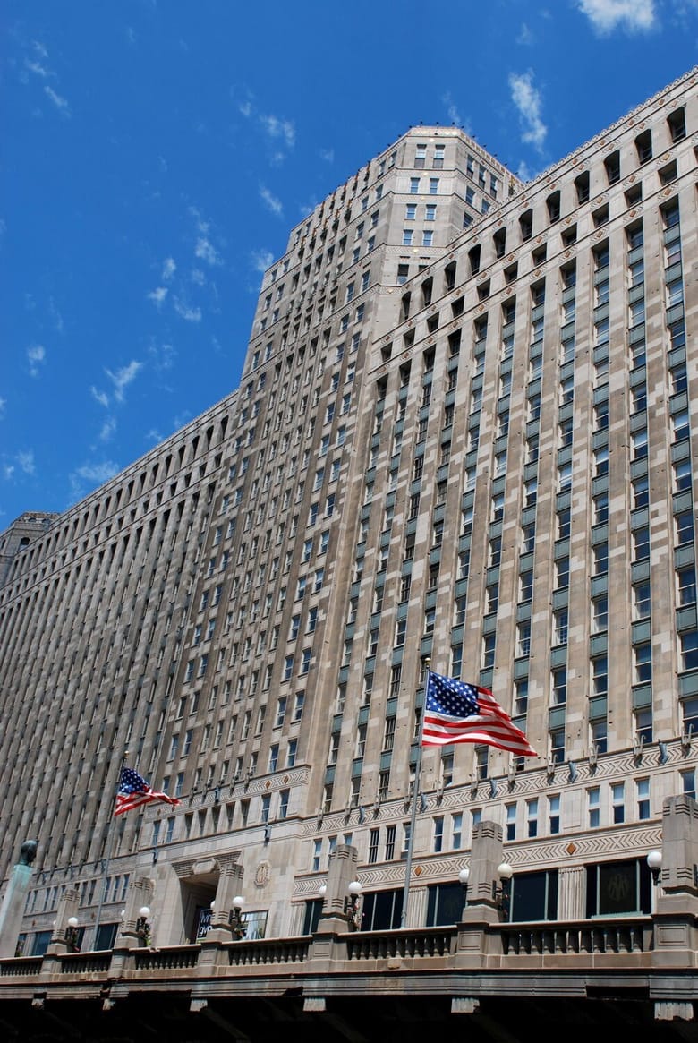 Merchandise Mart's river-facing entrance in Chicago, Illinois, showcasing its grand Art Deco architecture with limestone detailing and windows overlooking the Chicago River.
