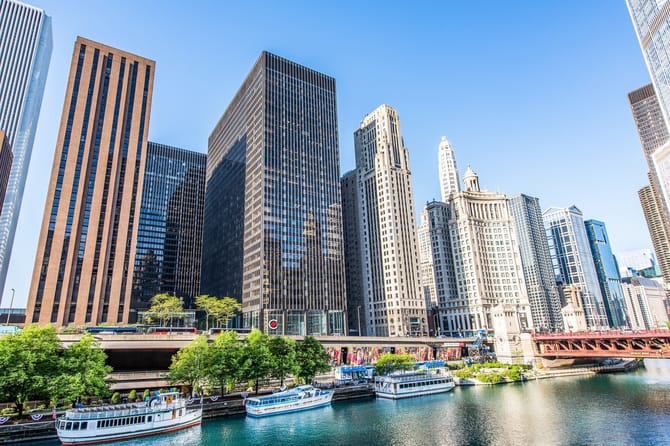 Skyscrapers along a river with boats in the water