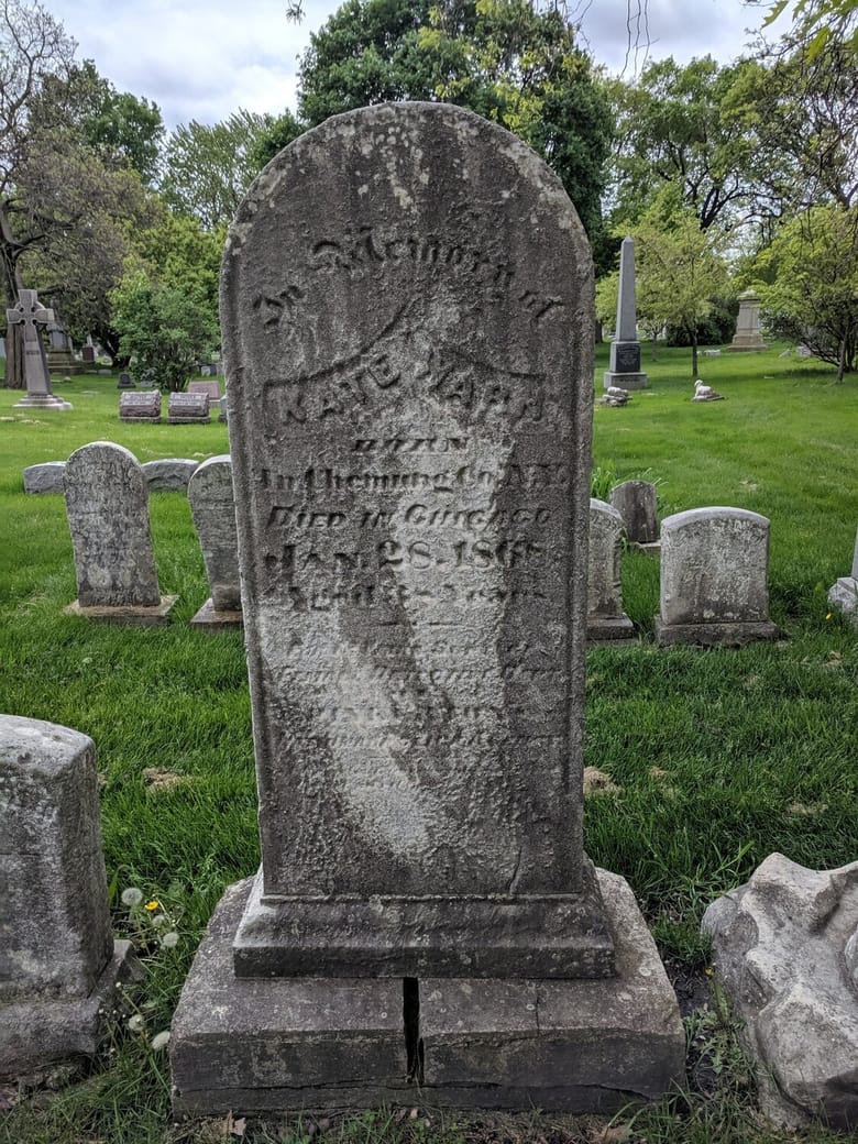 A photo of an old and worn headstone marking the Kate Warn grave