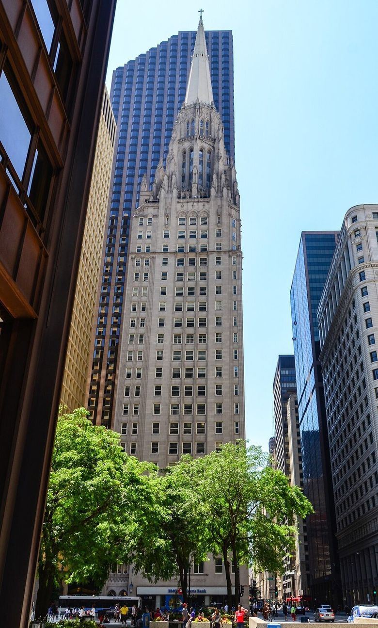 Exterior shot of a tall beige building with an ornate pointed top